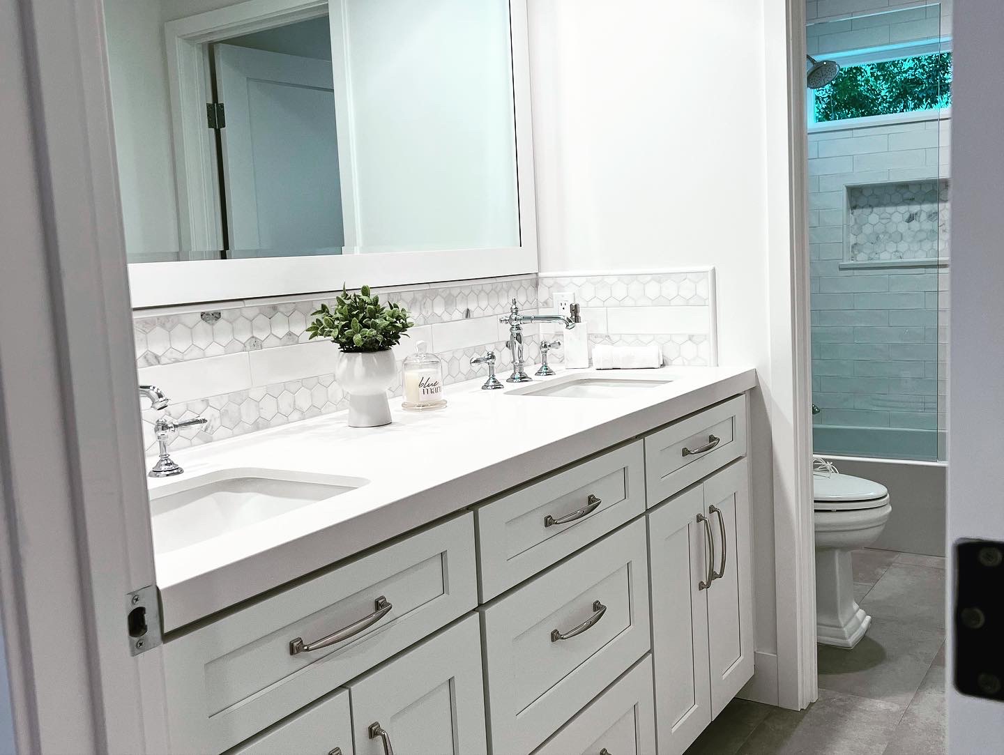 Bathroom double vanity with herringbone tile shower