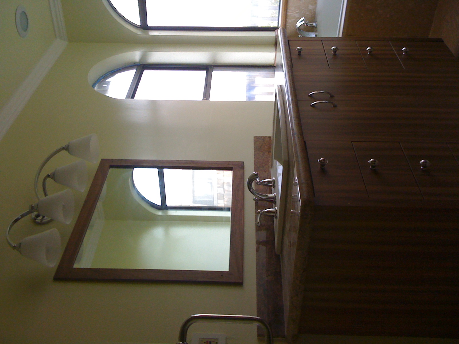 Bathroom with custom walnut vanity and oval mirror