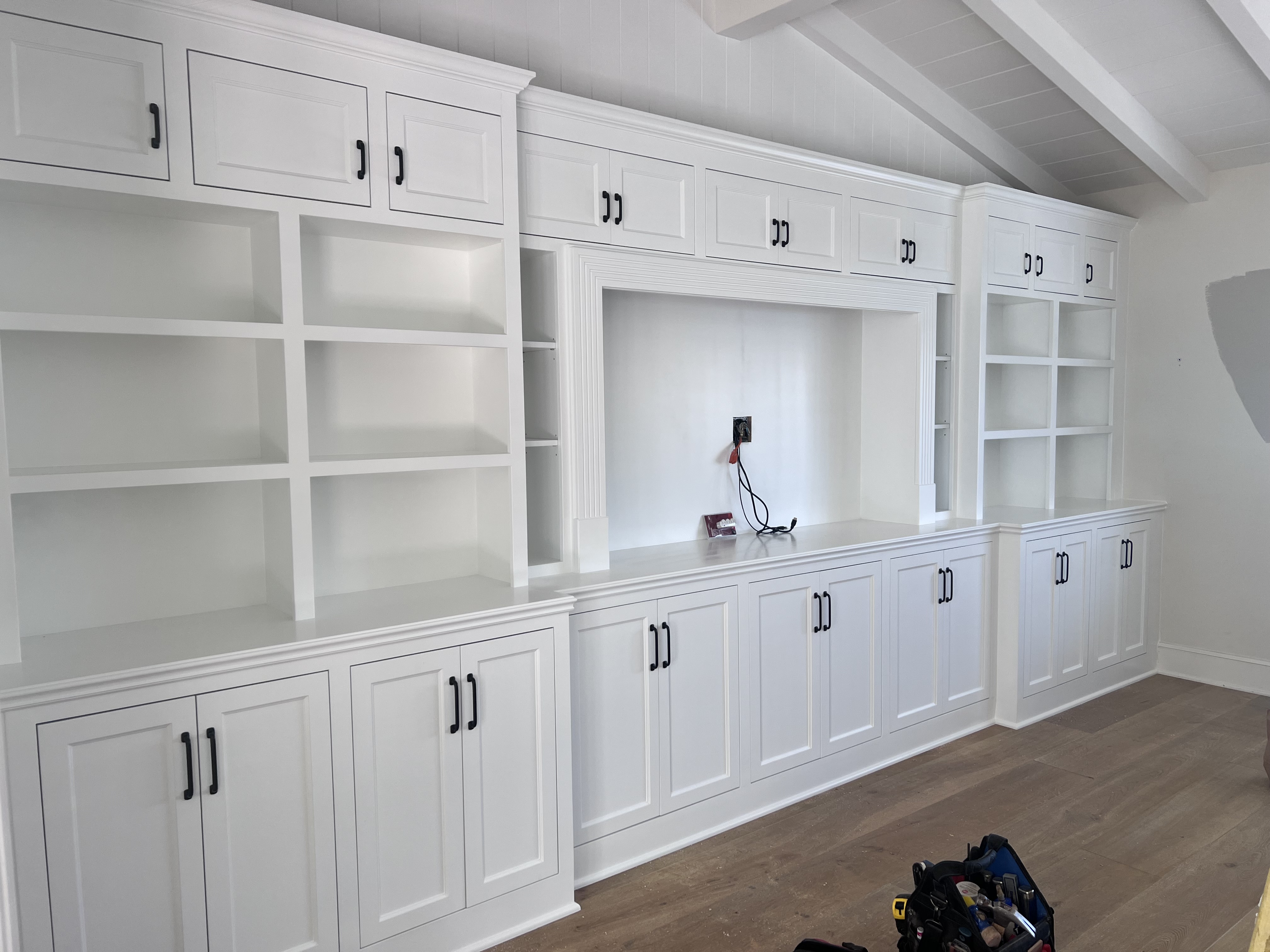 Full wall built-in entertainment center with upper cabinets and open shelving