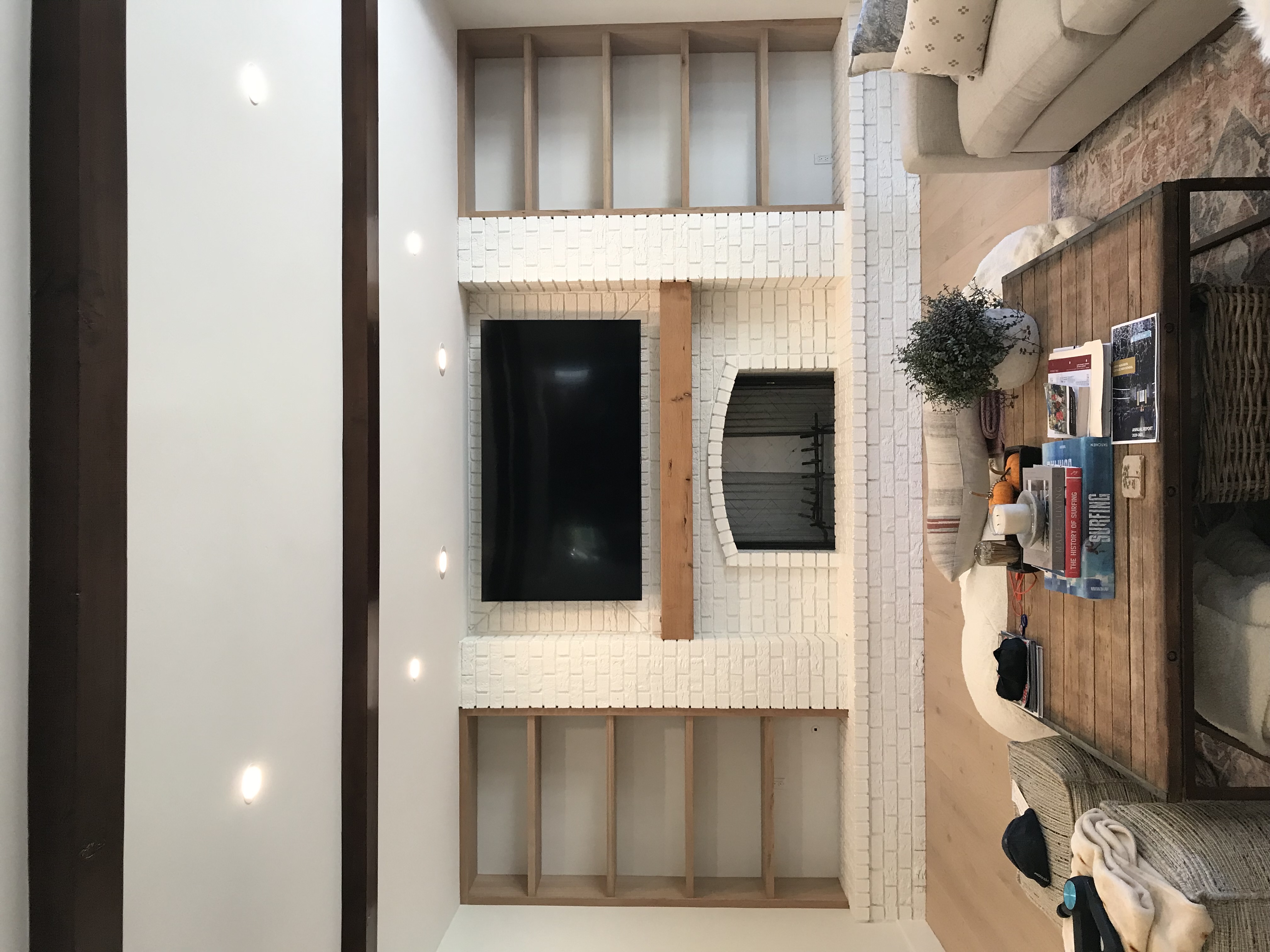 Custom fireplace and TV surround with white tile and wood framing