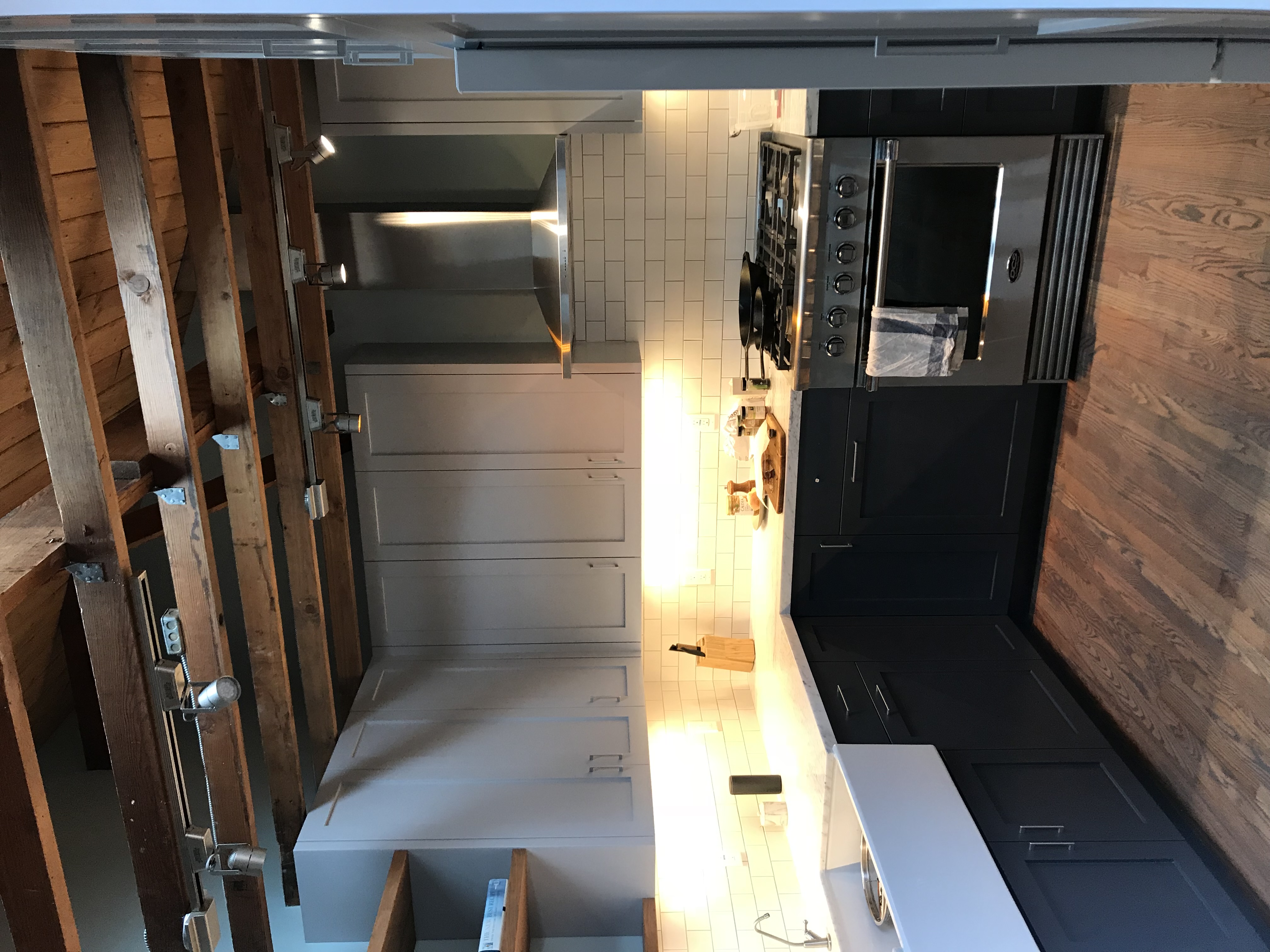 Two-tone kitchen remodel with exposed beams and subway tile