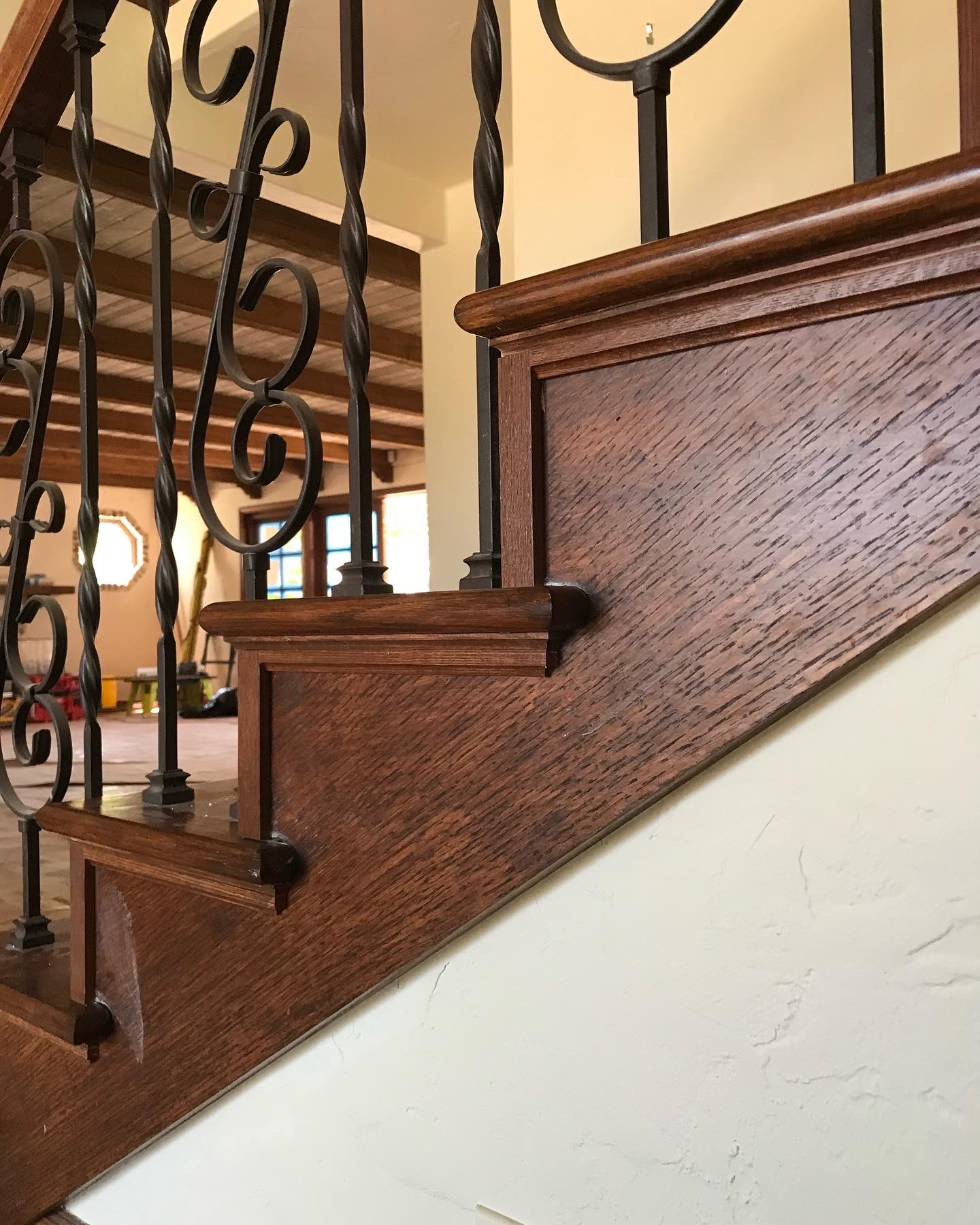Finished stair stringer with dark oak stain and ornate iron balusters