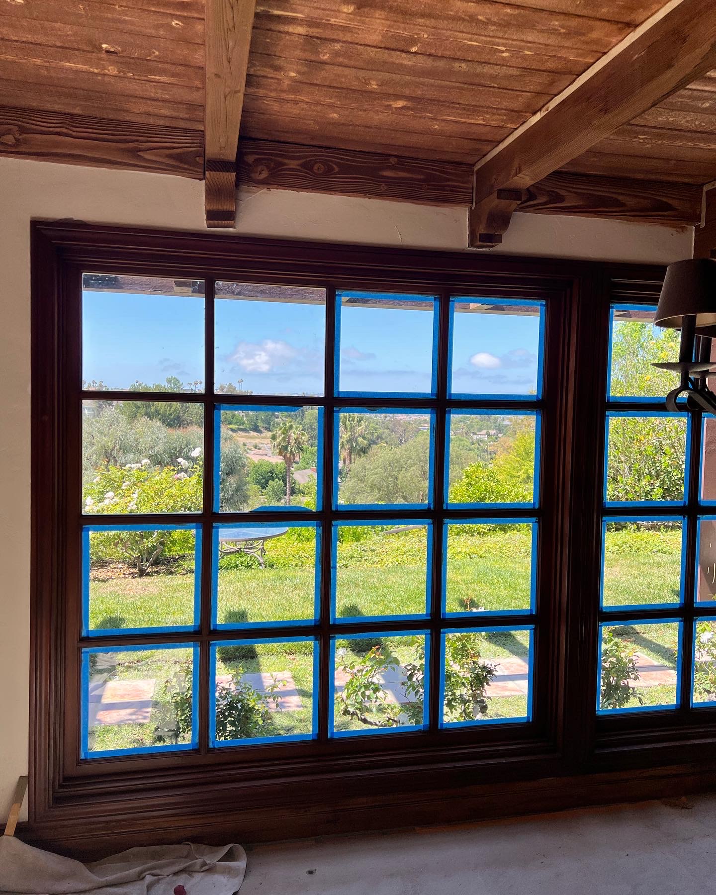 Large grid window with dark stained wood frame and scenic view